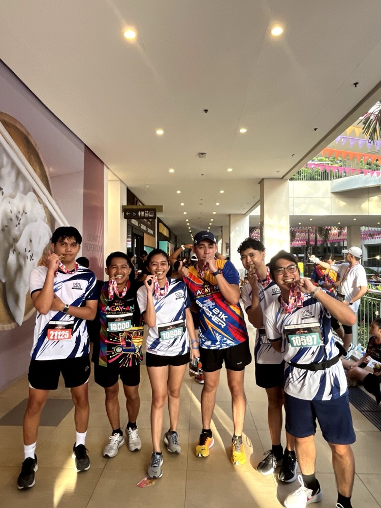 Staff with race bibs and medals after a company fun run