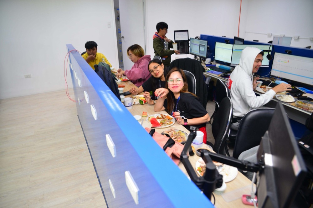 Colleagues eating together at their desks during a team lunch